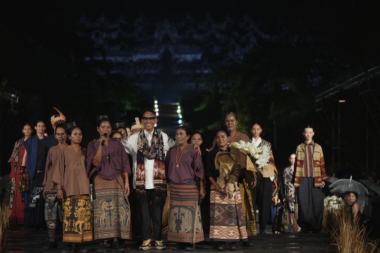 Desainer Edward Hutabarat berfoto bersama penrajin kain tenun Sumba di penghujung fashion show untuk koleksi Autumn/ Winter 2023 di pelataran Candi Borobudur, Rabu (30/11/2022) malam.