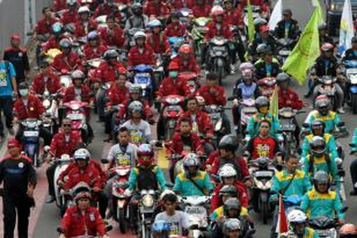 Ribuan buruh dari berbagai organisasi berunjuk rasa memperingati Hari Buruh Internasional, melintasi Jalan MH Thamrin, Jakarta Pusat, Kamis (1/5/2014). Hari Buruh Internasional ditetapkan sebagai hari libur nasional untuk kali pertama di tahun ini, diperingati dengan berunjuk rasa menuntut upah layak, penghapusan outsourcing, dan penolakan terhadap undang-undang Badan Penyelenggara Jaminan Nasional. TRIBUNNEWS/HERUDIN