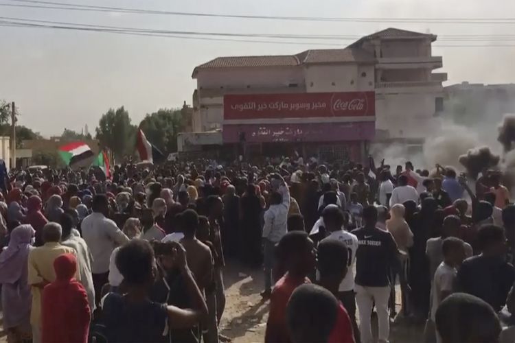 Warga membakar ban dan menutup jalan saat menggelar demo di Khartoum untuk menentang kudeta Sudan pada Senin (25/10/2021). Jenderal tertinggi Abdel Fattah Al-Burhan mengumumkan keadaan darurat dan membubarkan pemerintahan transisi demokrasi.