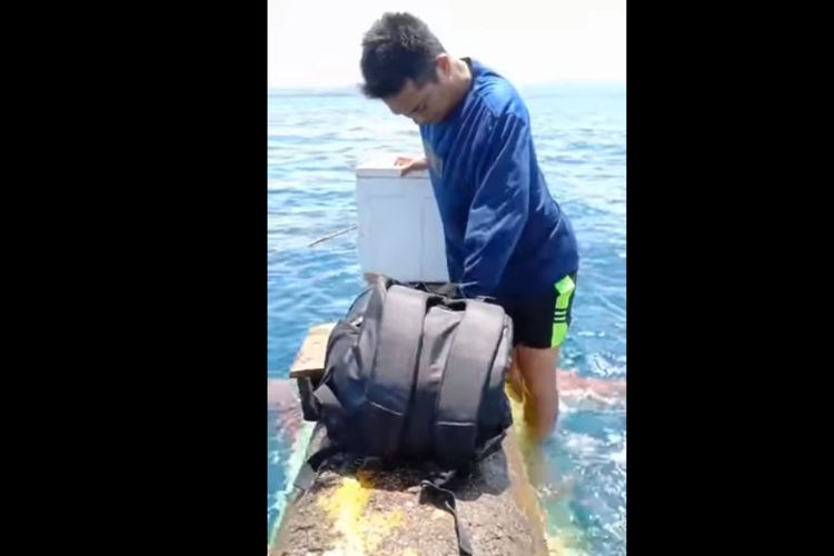 Kondisi salah seorang nelayan yang bertahan di sisi badan perahu kayu yang terbalik di sekitar Pulau lahe, Pohuwato. Dalam musibah ini ada 4 orang nelayan yang terombang-ambing di tengah laut sebelum diselamatkan petugas.