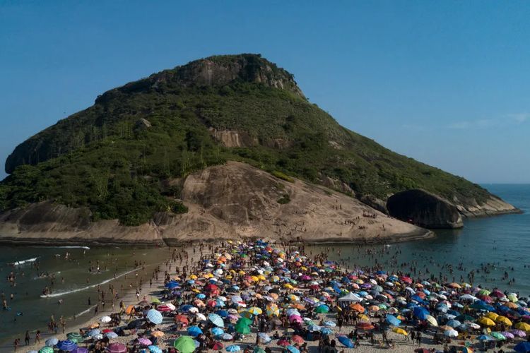 Penduduk Rio de Janeiro Brasil memadati pantai karena cuaca panas ekstrem pada Minggu (17/3/2024).