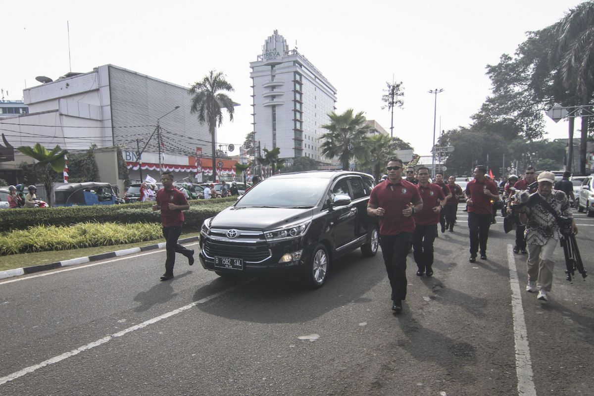 Paspampres menjaga mobil yang membawa Capres petahana Joko Widodo menuju Gedung Komisi Pemilihan Umum (KPU), Jakarta, Jumat (10/8). Joko Widodo dan Maruf Amin akan melakukan pendaftaran Calon Presiden dan Wakil Presiden periode 2019-2024. ANTARA FOTO/Dhemas Reviyanto/foc/18.