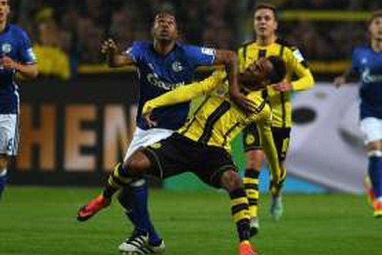 Penyerang Borussia Dortmund, Pierre-Emerick Aubameyang (kanan), berduel dengan bek Schalke, Naldo, dalam lanjutan Bundesliga di Signal Iduna Park, Sabtu (29/10/2016).