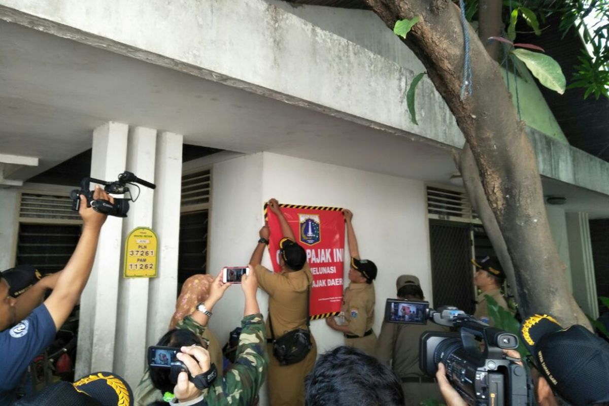 Petugas Unit Pelayanan Pajak dan Retribusi Daerah (UPPRD) Kecamatan Taman Sari memasang stiker tunggakan PBB-P2 di rumah yang beralamat di jalan Mangga Besar Gg Buntu 93F, Taman Sari, Jakarta Barat, Senin (17/7/2017).