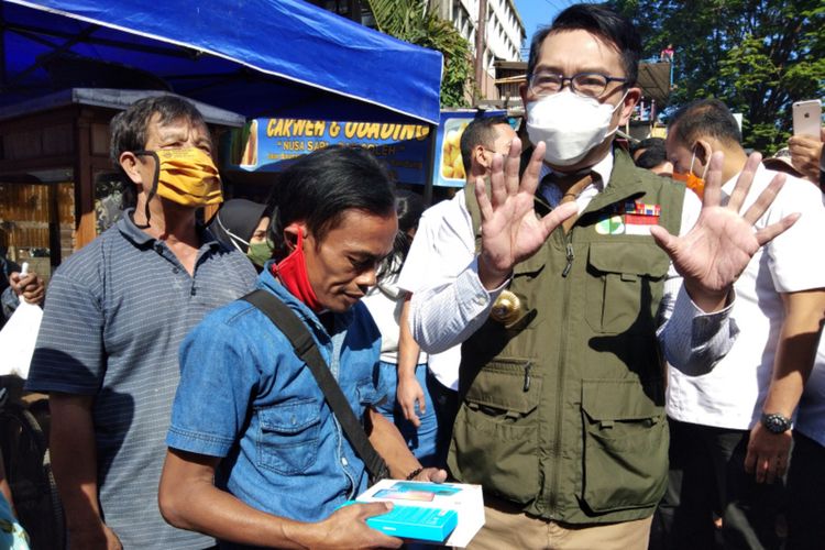 Gubernur Jawa Barat Ridwan Kamil saat memberikan hadiah berupa gawai kepada Ade Londok setelah viral mempromosikan Odading Mang Oleh di Jalan Baranangsiang, Kota Bandung, Rabu (16/9/2020).