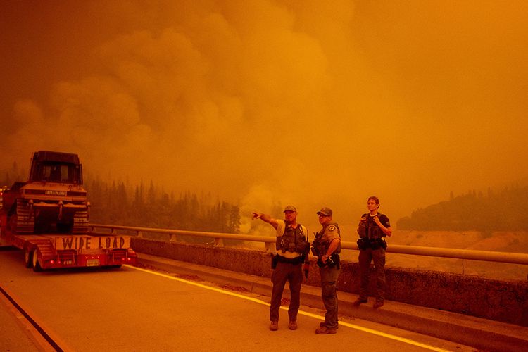 Petugas keamanan dan pemadam kebakaran menunggu untuk memasuki area yang dirambah api saat berlangsung kebakaran di Butte County, Oroville, California, Rabu (9/9/2020). Kebakaran terbesar dalam sejarah California itu dilaporkan telah menghancurkan 470 ribu hektar vegetasi kering dan 3,1 juta hektar lahan terbakar.