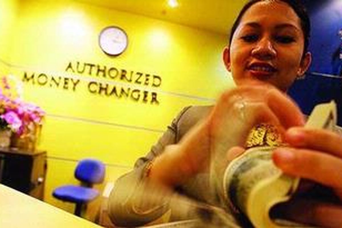 Karyawan di penukaran valuta asing di Kawasan Niaga Terpadu Sudirman, Jakarta, menghitung lembaran uang dollar AS. 