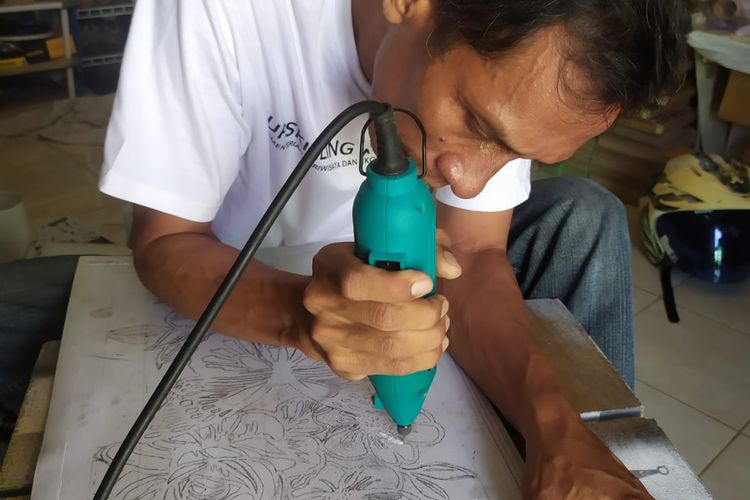 Potret Alip Damanto, owner Syahda Craft ketika memproduksi sebuah hiasan dinding ukir. Ia hanya menggunakan alat-alat konvensional untuk memotong paralon hingga proses finishing. 