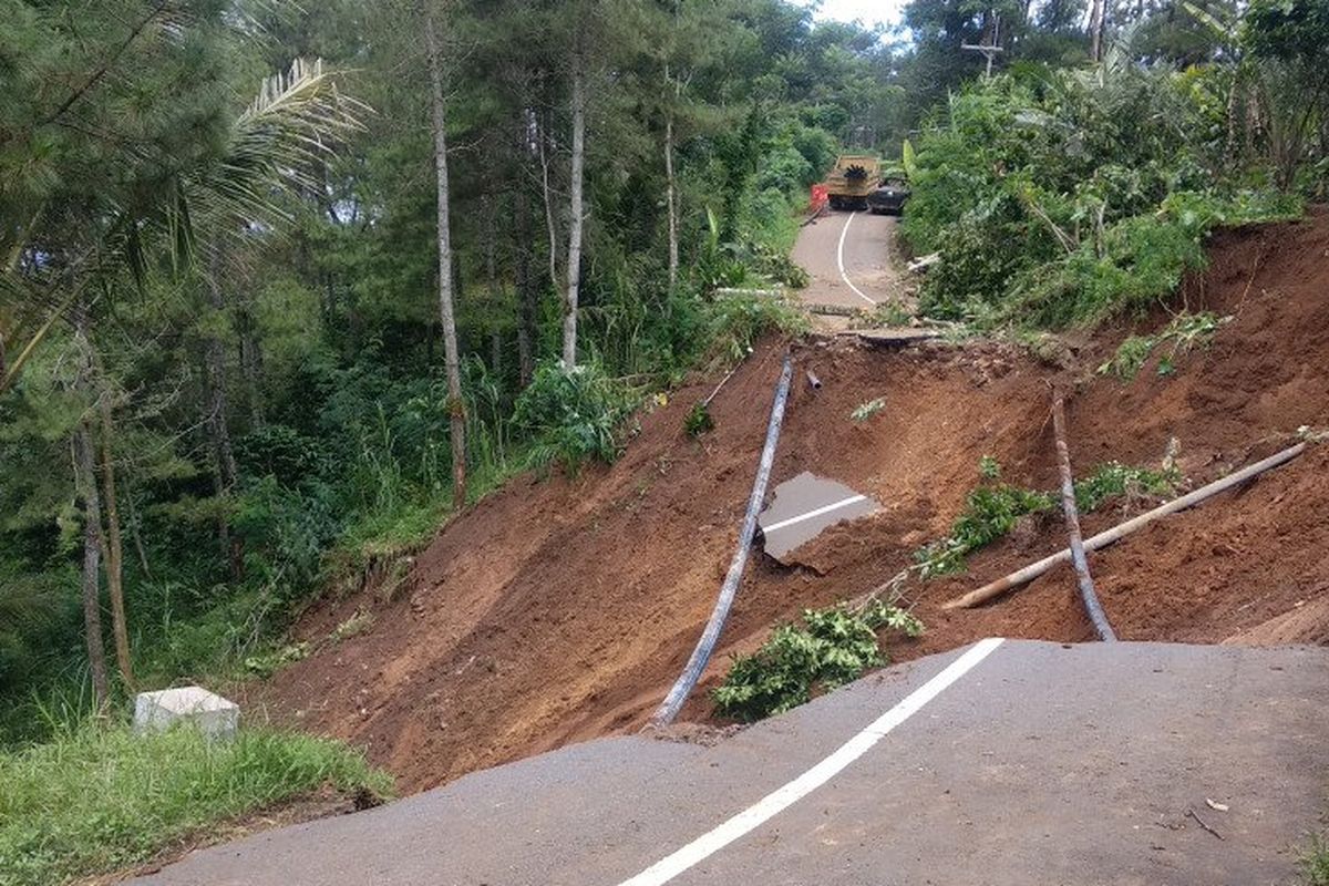 Pekerja beraktivitas di sekitar lokasi jalan antarkecamatan Trenggalek-Bendungan yang amblas terseret longsor di Desa Suren Lor, Trenggalek, Senin (6/4/2020).