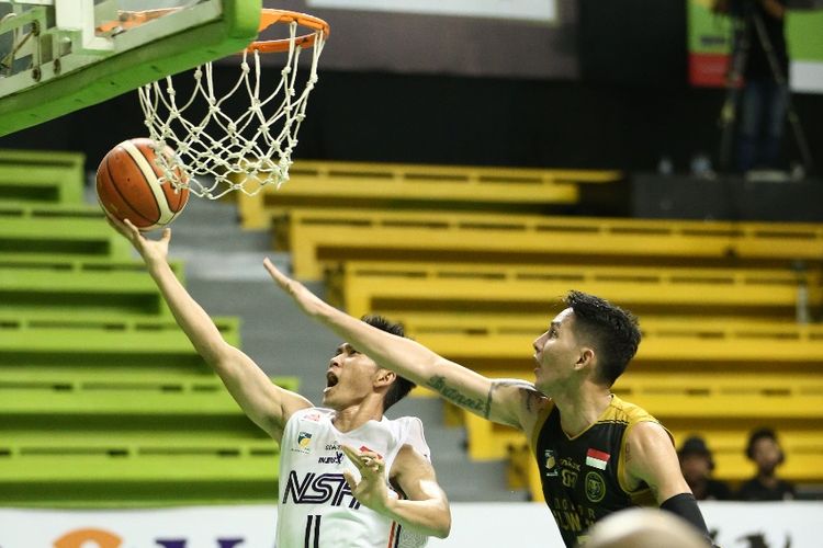 Pemain NSH Jakarta Andre Rorimpandey (putih) berupaya memasukkan bola ke ring pada laga seri keenam IBL Pertamax 2018-2019 melawan Bogor Siliwangi, di GOR Pacific, Surabaya, Minggu (3/2/2019) siang. 