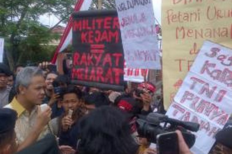 Gubernur Jawa Tengah Ganjar Pranowo berdialog dengan mahasiswa yang mengadang mobilnya saat memasuki kampus di Purwokerto, Minggu (23/8/2015).
