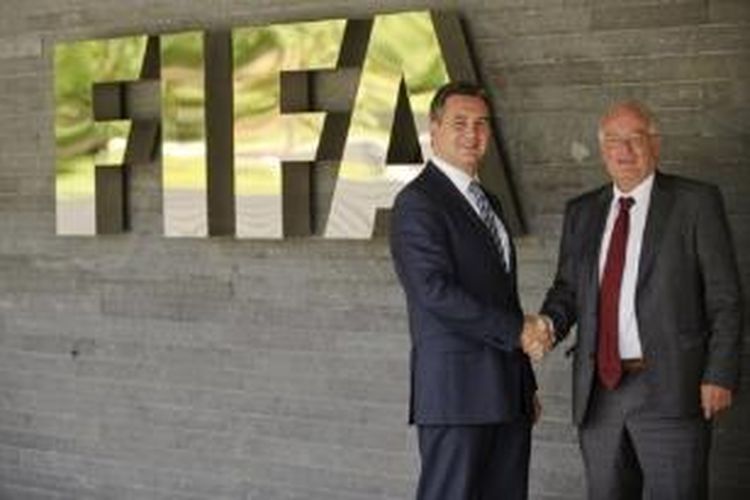 Ketua Badan Investigasi FIFA Michael Garcia (kiri) dan Ketua Badan Pengadilan FIFA Hans-Joachim Eckert (kanan) berfoto di depan marka FIFA di Zurich, pada 27 Juli 2012.