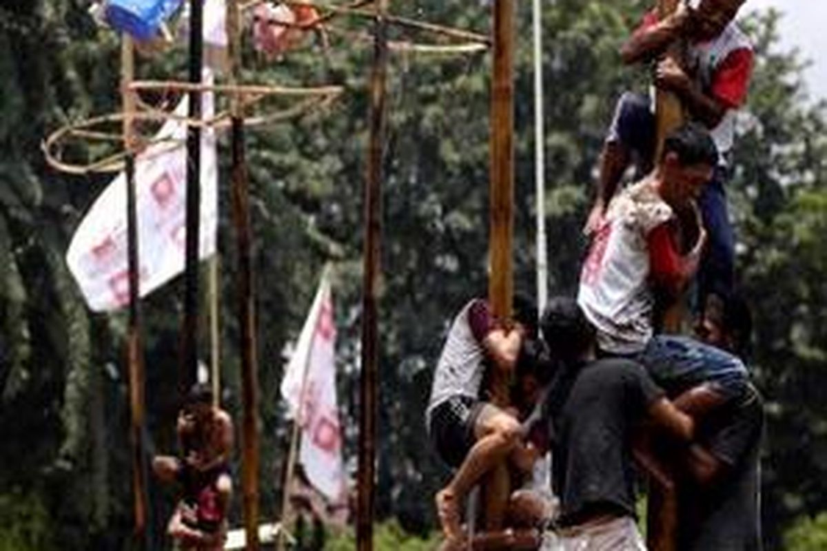 Berjuang keras bahu membahu dalam panjat pinang saat kampanye Partai Matahari Bangsa di Lapangan Blok S, Rabu (25/3).