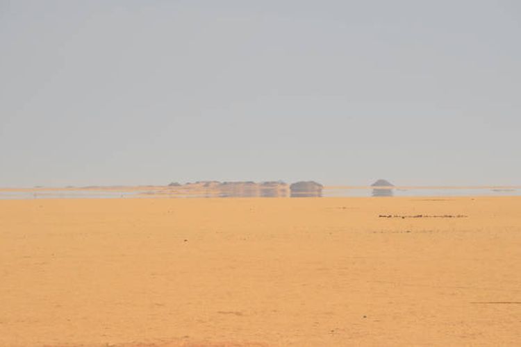 Ilustrasi ilusi oasis di padang pasir sebagai sebuah fatamorgana.