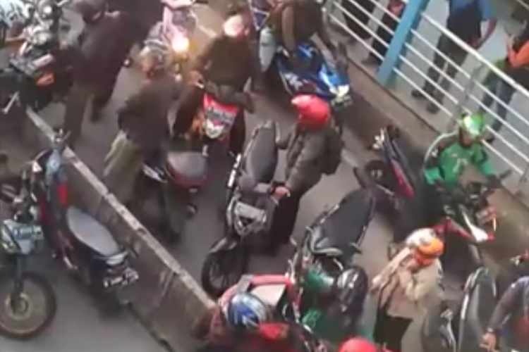 Pengendara angkat motor dari jalur Transjakarta di depan halte Indosial, daan Mogot Jakarta Barat pada Selasa (26/3/2019)