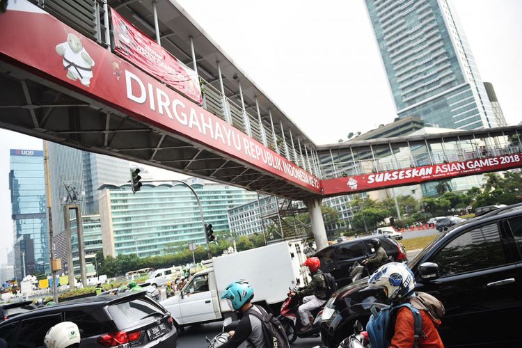 Pengguna jalan melintas di bawah jembatan penyeberangan orang (JPO) Bundaran HI di Jakarta, Selasa (24/7). Pemprov DKI Jakarta berencana membongkar JPO tersebut karena dianggap menghalangi pandangan ke arah Patung Selamat Datang dan tidak ramah disabilitas sehingga akan diganti dengan pelican crossing atau lampu lalu lintas untuk penyeberangan. ANTARA FOTO/Akbar Nugroho Gumay/wsj/18.