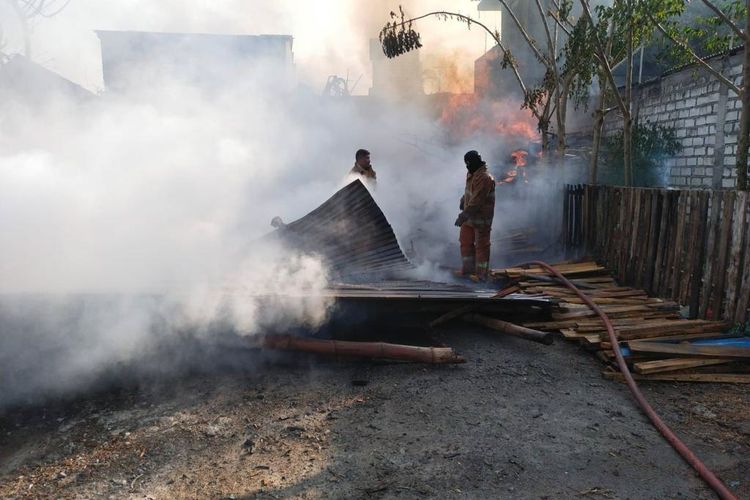 Petugas saat memadamkan api yang membakar tumpukan palet pada gudang di Desa Leran, Kecamatan Manyar, Gresik, Jawa Timur, Selasa (24/10/2023).
