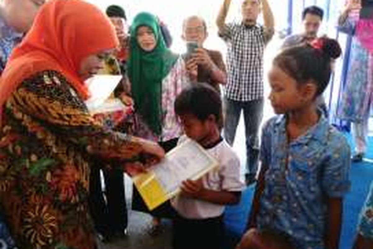 Menteri Sosial Khofifah Indar Parawansa, menyerahkan akte lahir kepada seorang anak di Kolam Renang Laros Gelanggang Olah Raga (GOR) Rawa Badak Selatan, Semper, Koja, Jakarta Utara, Kamis (19/5/2016).