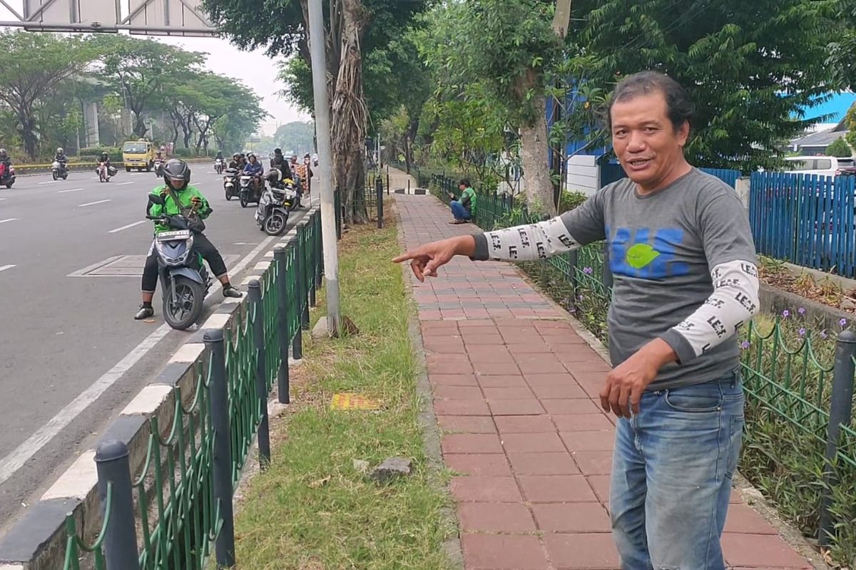 Royal Sianturi (47), pedagang minuman setempat, sedang menunjukkan lokasi keributan antara dua pengemudi motor terjadi di Jalan Mayjen Sutoyo, Cawang, Jakarta Timur, Selasa (7/11/2023).