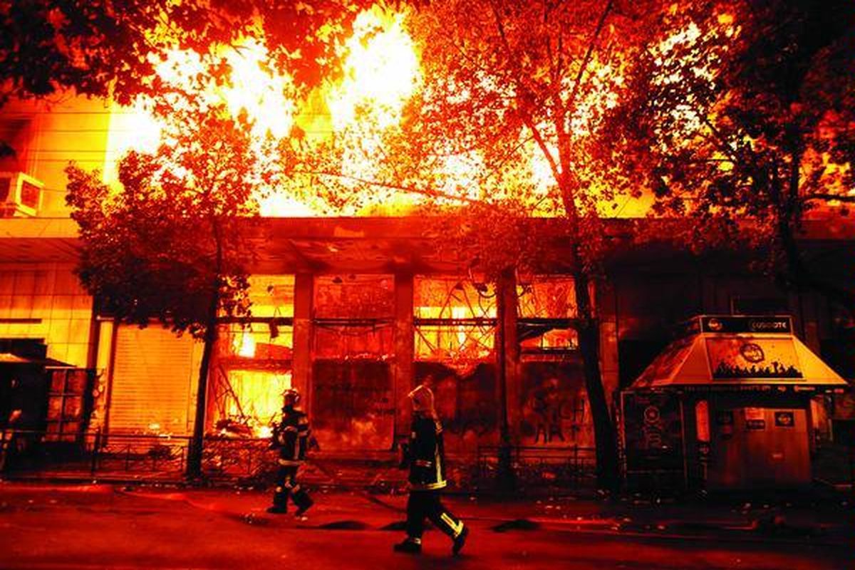 Sebuah bioskop terbakar di Athena, Yunani, Minggu (12/2). Kerusuhan merebak di pusat kota Athena dan sedikitnya 10 bangunan dibakar oleh massa yang marah, Minggu petang, menjelang pemungutan suara di parlemen Yunani yang akhirnya menyetujui paket penghematan baru untuk menghindari kebangkrutan negara itu.