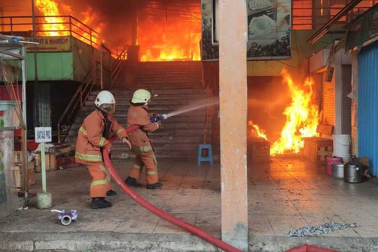 Petugas Pemadam Kebakaran Saat Memadamkan Kobaran Api di Pasar Kembang Surabaya, Minggu Sore (22/8/2021).