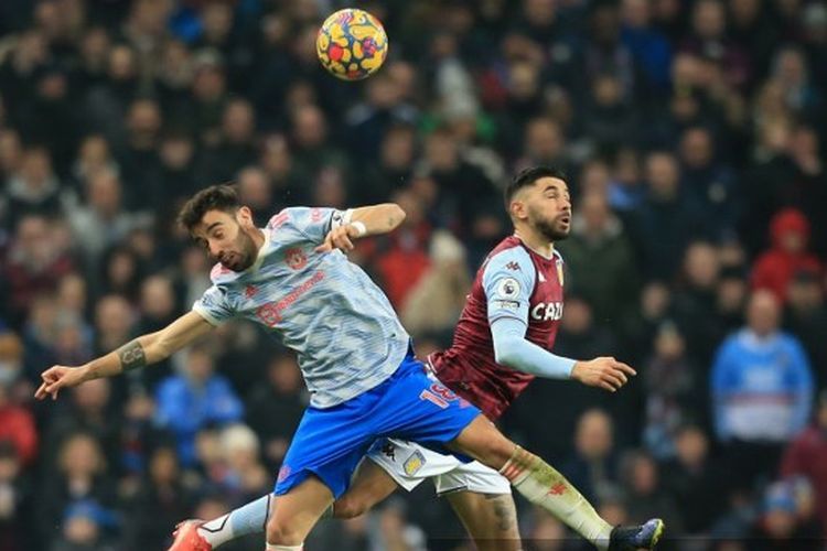 Gelandang Man United, Bruno Fernandes, terlibat duel udara dengan personel lini tengah Aston Villa, Morgan Sanson, dalam laga Liga Inggris 2021-2022 di Stadion Villa Park, 15 Januari 2022.