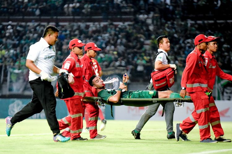 Otavio Dutra harus ditandu keluar saat laga Persebaya vs Persela di Stadion Gelora Bung Tomo, Sabtu (11/5/2019), lantaran bek asal Brazil itu mengalami fracture tulang hidung 
