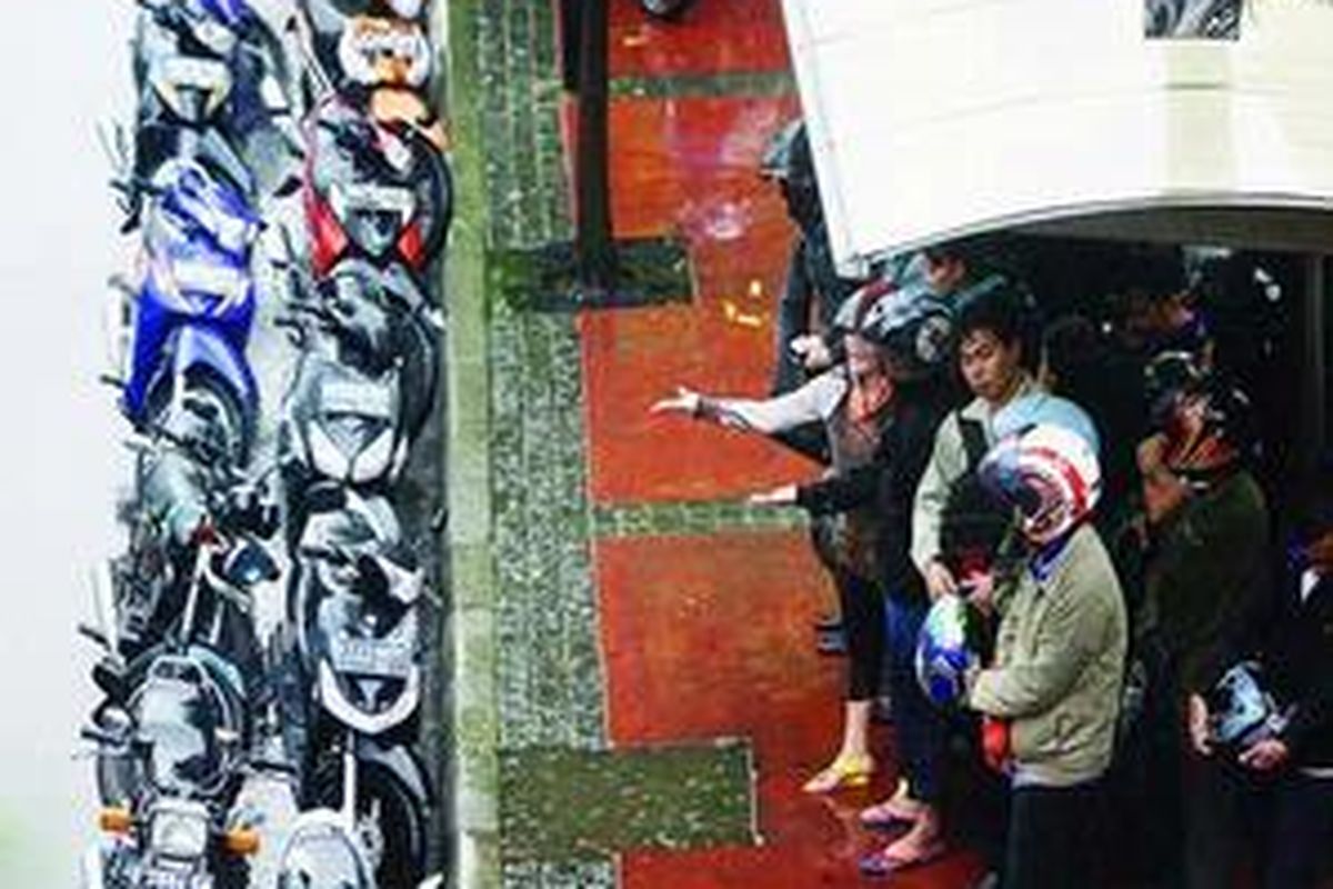 Sejumlah sepeda motor diparkir di pinggir Jalan MH Thamrin, Jakarta Pusat, saat ditinggal pemiliknya berteduh dari hujan, Senin (16/11). Jakarta dan kawasan sekitarnya diprediksi telah mulai memasuki musim hujan.