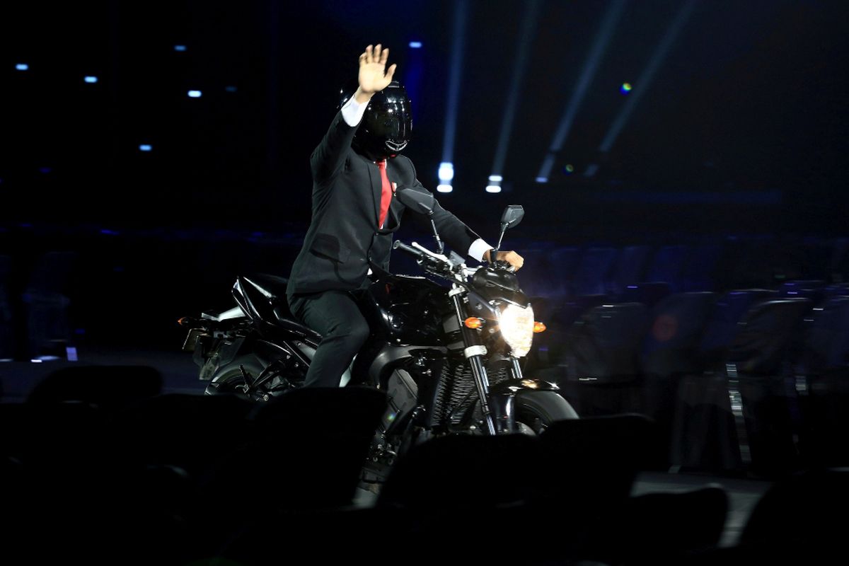 Presiden Joko Widodo mengendarai sepeda motor pada Upacara Pembukaan Asian Games ke-18 Tahun 2018 di Stadion Utama Gelora Bung Karno, Senayan, Jakarta, Sabtu (18/8/2018).