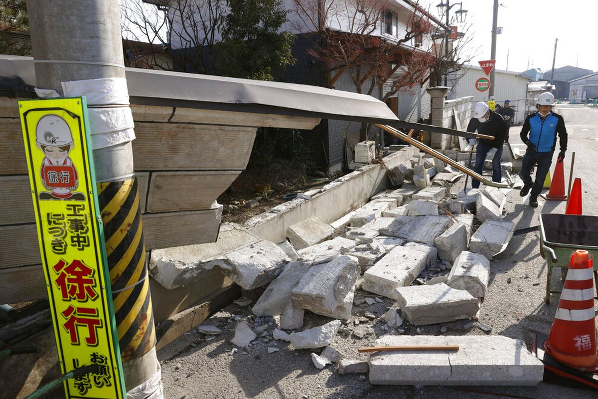 Penduduk di timur laut Jepang pada Minggu membersihkan kekacauan di toko dan rumah setelah gempa bumi pada Sabtu (13/2/2021).
