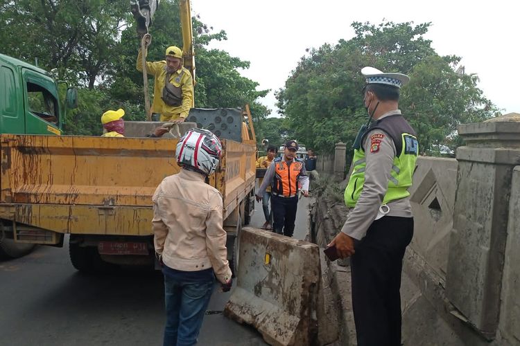 Petugas mengamankan lokasi patahnya pagar pembatas Jembatan Marunda Cilincing, Jakarta Utara. Pembatas itu diketahui patah pada Selasa (27/12/2022). 