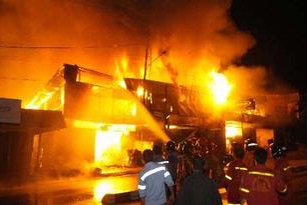 Petugas berusaha menjinakkan kobaran api yang melalap beberapa ruko dan rumah penduduk di Jalan Soekarno-Hatta Km 0.5 Muara Rapak, Balikpapan, Kalimantan Timur, Kamis (27/1/2011) malam hingga Jumat (28/1/2011) dini hari.  