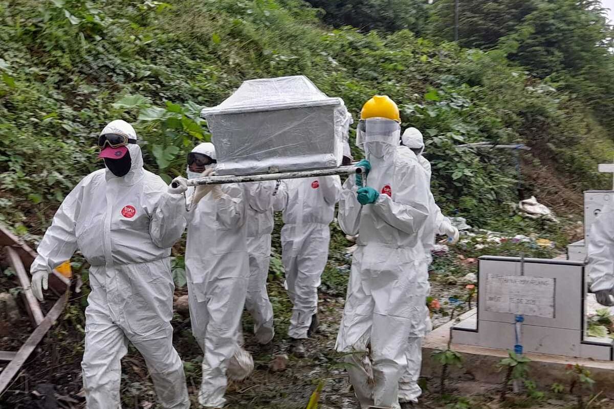 Tim relawan Covid-19 memakamkan seorang pasien positif yang meninggal dunia di tempat pemakaman umum (TPU) di Desa Hunuth, Kota Ambon, Rabu sore (7/7/2021)