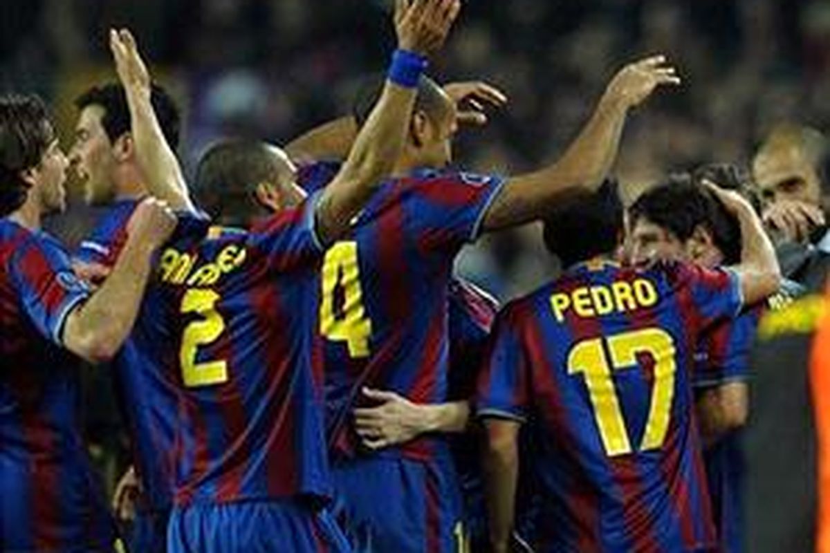 Lionel Messi (kanan) mendapat pujian dari rekan-rekannya setelah mencetak gol kedua ke gawang Stuttgart. Barcelona akhirnya menang 4-0 dan lolos ke perempat final Liga Champions.