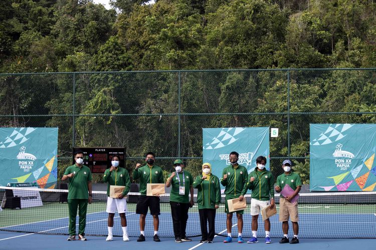 Gubernur Jawa Timur Khofifah Indar Parawansa menyerahkan bonus mentas kepada atlet tenis lapangan Jatim yang berhasil menyabet emas nomor beregu putra di Lapangan Tenis Sian Soor Walikota, Jayapura, Minggu (3/10/2021) sore.
