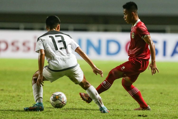 Pemain timnas U17 Indonesia Habil Yafi berebut bola dengan pemain timnas U17 Guam Nicholas Moore pada pertandingan Kualifikasi Piala Asia U17 2023 di Stadion Pakansari, Kabupaten Bogor, Senin (3/10/2022).  Indonesia menang 14-0 atas Guam.