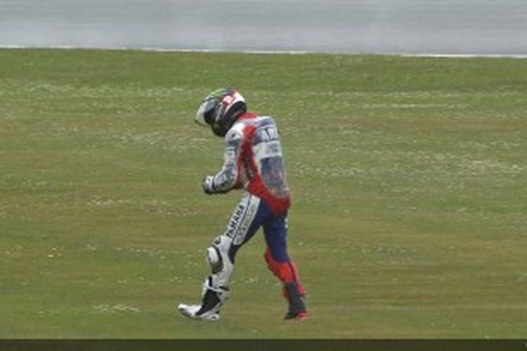 Pebalap Yamaha asal Spanyol, Jorge Lorenzo, berjalan sambil memegang pergelangan tangan kiri setelah kecelakaan parah pada sesi latihan bebas kedua GP Belanda di Sirkuit Assen, Kamis (27/6/2013).