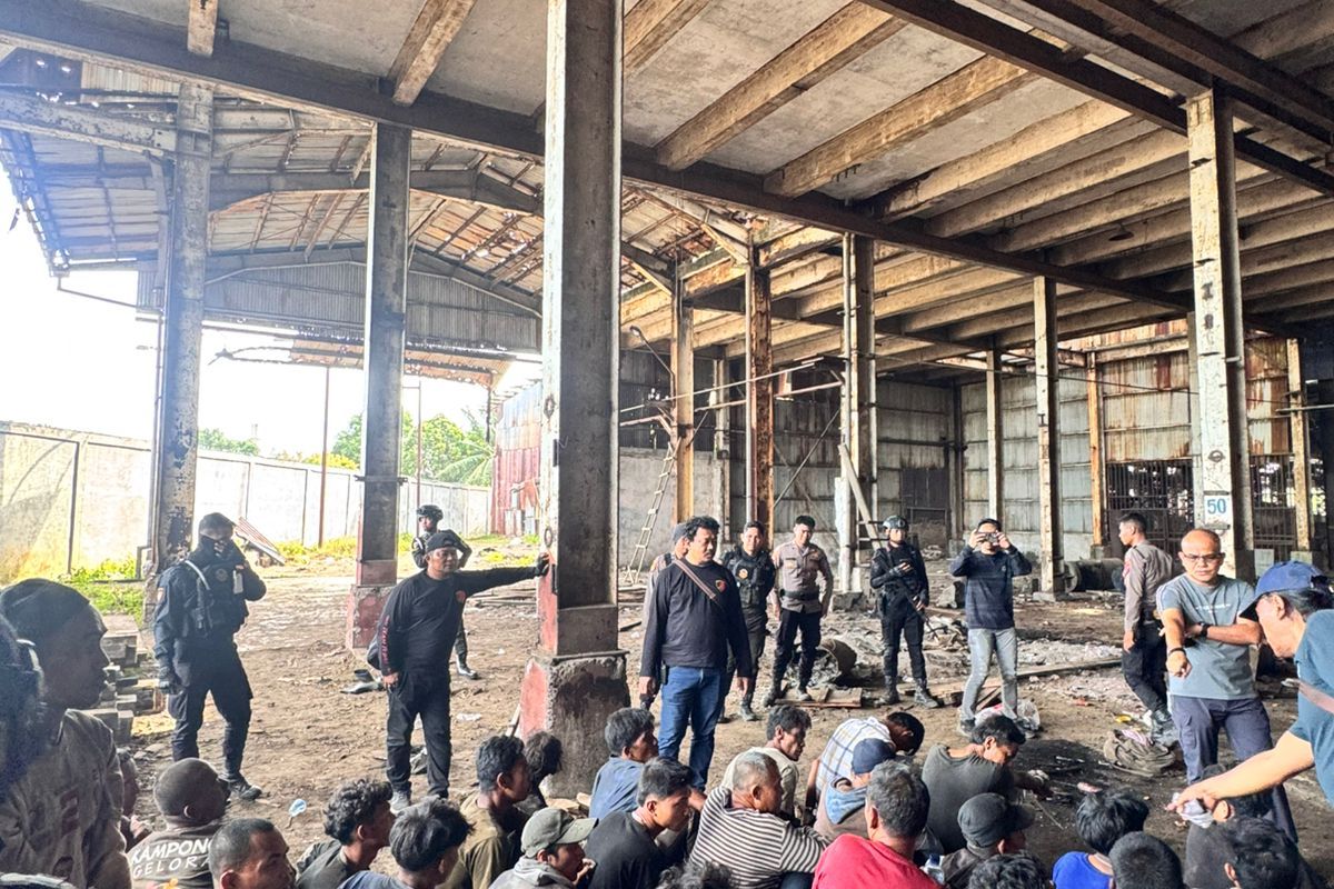 Polisi saat menangkap warga yang terlibat penjarahan besi pabrik PT ARB di Jalan Yos Sudarso, Kota Medan, Minggu (20/6/2025).
