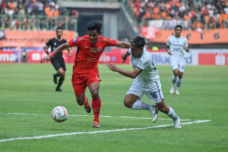 Firza Andika bek Persija (merah) melindungi bola dari pemain Persib Daisuke Sato dalam pertandingan pekan ke-11 Liga 1 2023-2024 antara Persija vs Persib di Stadion Patriot Candrabhaga Bekasi, Sabtu (2/9/2023). 