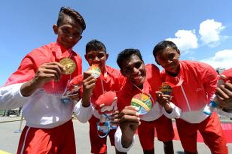 Atlet rowing Indonesia Mochamad Ali Darta Lakiki, Rendi Syuhada Anugrah, Muhad Yakin, dan Denri Maulidzar Al Ghiffari (kiri ke kanan), menunjukkan medali emas usai menjadi yang tercepat di nomor Men's Lightweight Four (500m) SEA Games 2015 di Marina Chanel, Singapura, Kamis (11/6/2015). Mereka menjadi penyumbang medali emas bagi Indonesia dengan catatan waktu 1:22,56 detik. KOMPAS/WAWAN H PRABOWO