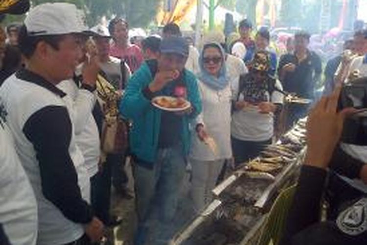 Pembaca acara Jeremy Teti (berjaket biru) menikmati udang galah bakar di acara pesta rakyat Nunukan, Kalimantan Utara, Sabtu (20/12/2014).