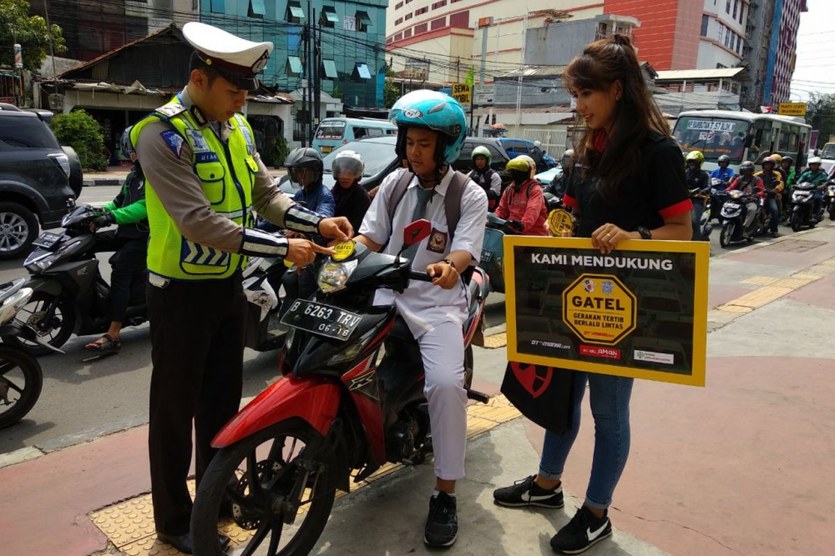 Petugas kepoliian dari NTMC Polri memberikan penyuluhan pada pengendara yang menggunakan trotoar tidak sesuai peruntukannya pada kampanye Gerakan Tertib Lalu lintas Kompas Otomotif dan Otomania