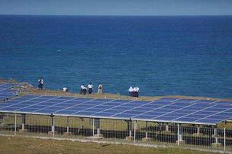 Pelajar berdiri di dekat panel surya yang digunakan untuk membangkitkan tenaga listrik di Baron Technopark, kawasan Pantai Baron, Gunung Kidul, Yogyakarta, Selasa (5/6/2012). 