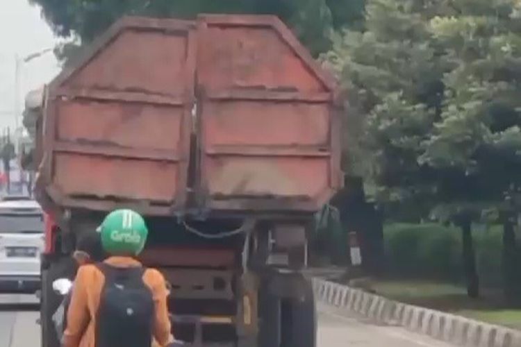 Tangkapan layar truk pengakut sampah dalam kondisi pintu bak rusak melintas di Jalan Raya Lenteng Agung, Jakarta Selatan.