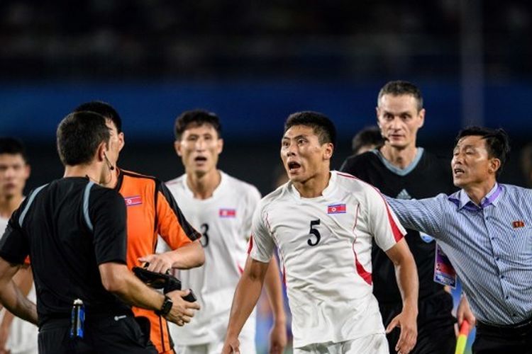 Pemain timnas Korea Utara, Kim Kyong Sok (tengah), berusaha menyerang wasit usai laga perempat final sepak bola putra Asian Games 2022 melawan Jepang yang digelar di Xiaoshan Sports Centre, Hangzhou, pada Senin (1/10/2023) malam WIB.