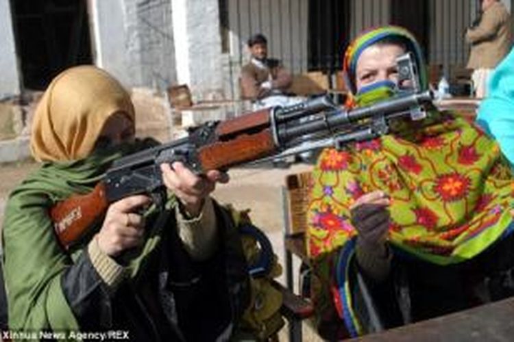 Dua orang guru perempuan di provinsi Khyber Pakhtunkhwa, Pakistan nampak tengah mempelajari senapan serbu legendaris AK-47. Pemerintah Pakistan memutuskan untuk melatih para guru di negeri itu cara menggunakan senjata untuk mengantisipasi terjadinya serangan teroris.