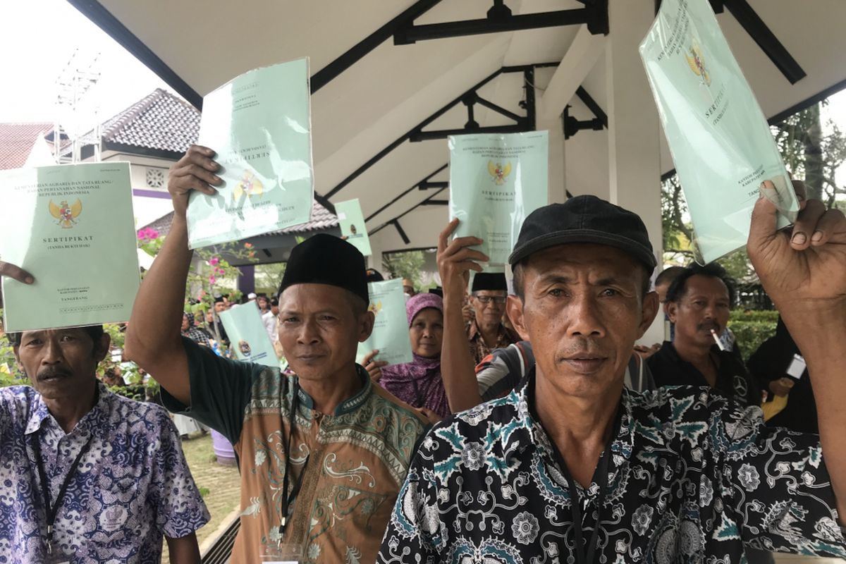 Sejumlah warga Kabupaten Tangerang, Banten, menunjukkan sertifikat tanahnya usai dibagikan oleh Presiden Joko Widodo (Jokowi) di Lapangan Maulana Yudha, Tigaraksa, Kabupaten Tangerang, Senin (18/2/2019)