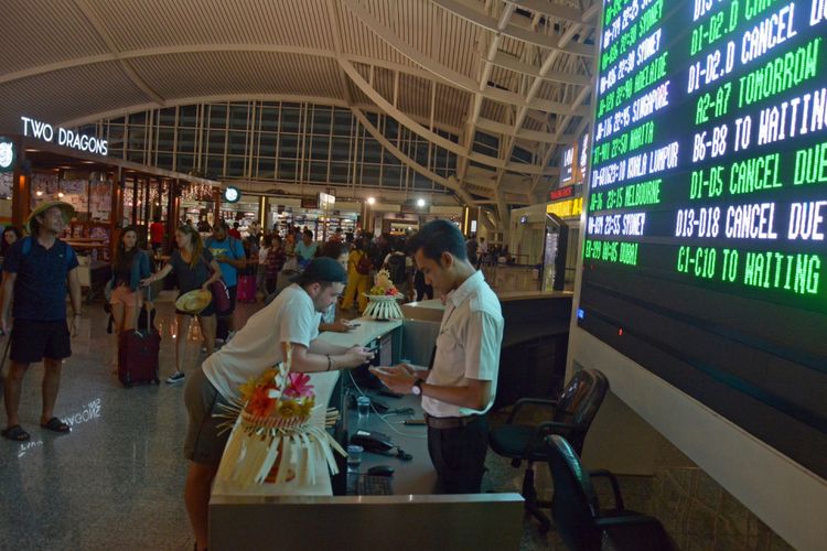 Calon penumpang menunggu jadwal penerbangan di Bandara Ngurah Rai Bali, Sabtu (25/11/2017) malam. Sebanyak 17 jadwal penerbangan internasional dari dan menuju Bali dibatalkan karena dampak erupsi Gunung Agung. 