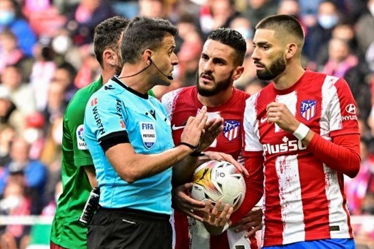 Koke (tengah) dan Yannick Carrasco (kanan) melancarkan protes ke wasit Jesus Gil Manzano pada pertengahan laga pekan ke-33 Liga Spanyol yang mempertemukan Atletico Madrid vs Granada di Stadion Wanda Metropolitano, Kamis (21/4/2022) dini hari WIB.