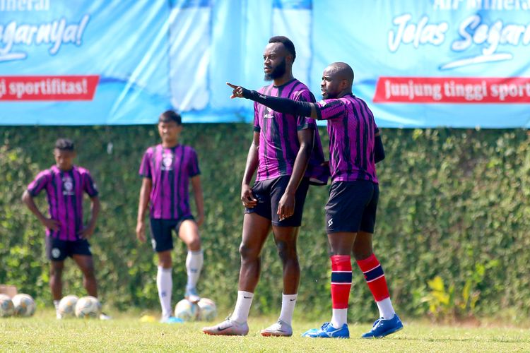 Pemain Arema FC Charles Lokolingoy dan Greg Nwokolo berdiskusi saat pemusatan latihan tim yang diadakan selama 3 hari di Lapangan Agro Kusuma Kota Batu, Jawa Timur, Senin (16/10/2023) pagi.